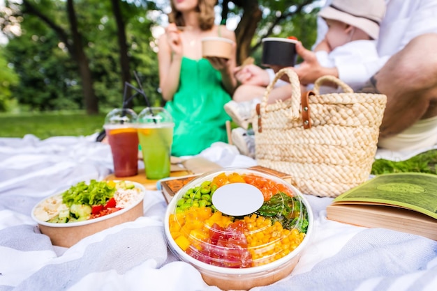 Familia en un picnic con poke en el parque