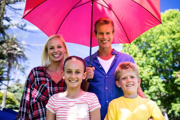 Familia de pie bajo paraguas