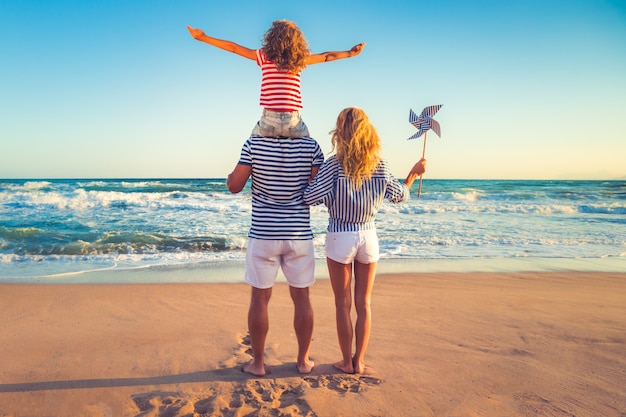 familia de pie en la playa y mirando el mar azul