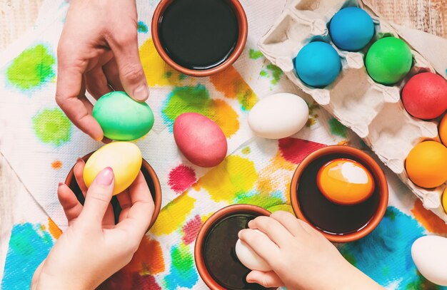 La familia pinta los huevos de pascua. Enfoque selectivo celebracion.