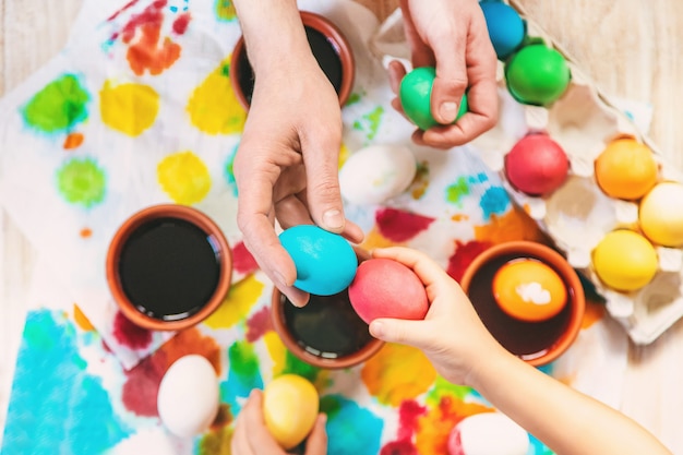 La familia pinta los huevos de pascua. Enfoque selectivo celebracion.