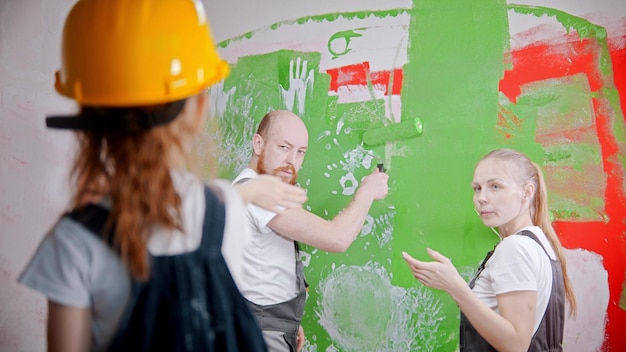 Família pintando paredes filhinha olhando para seus pais