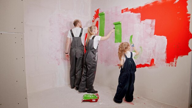 Família pintando paredes no novo apartamento na cor verde