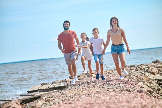 Familia en una playa. Una familia caminando en una orilla tomados de la mano