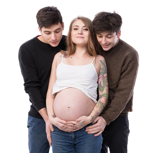 Família polígama moderna com uma esposa e dois maridos. Mulher grávida posando com dois jovens em um fundo branco