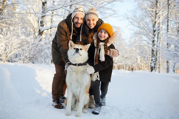 Família posando com cachorro ao ar livre