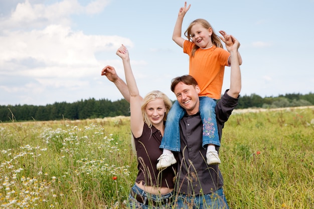 família posando em um campo de grama