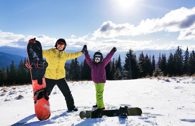 Familia de practicantes de snowboard en el resort de invierno en las montañas