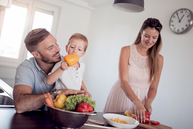 Foto familia preparando comida con hijo