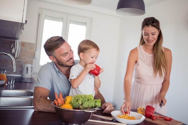 Foto familia preparando comida con hijo