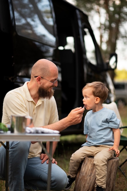 Foto família preparando o jantar no acampamento