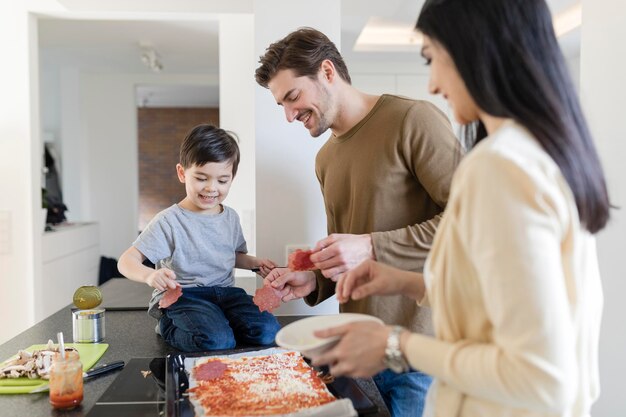 Familia preparando pizza en la cocina juntos