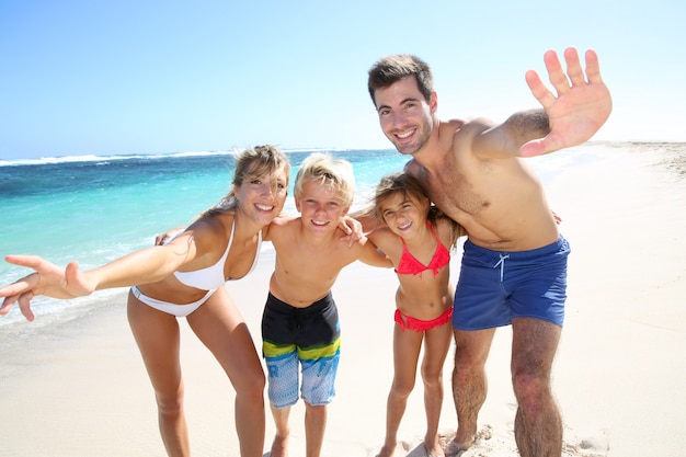 Família quatro, tendo divertimento, praia