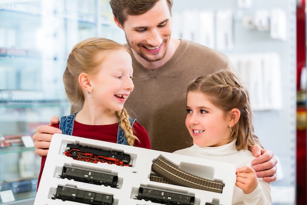 Familia que compra modelo de ferrocarril en juguetería