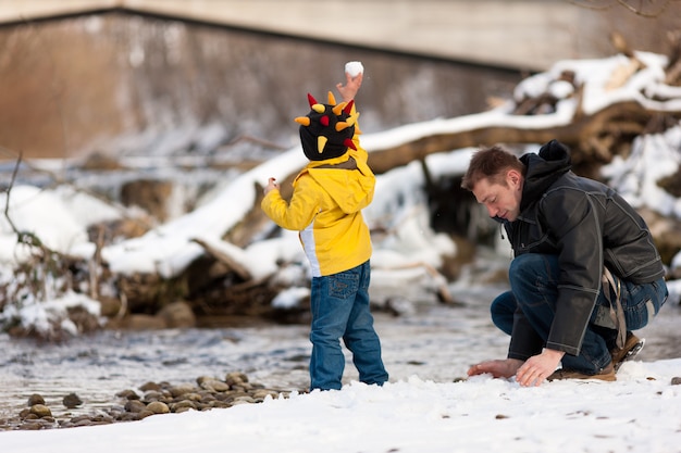 Familia que tiene caminata de invierno en el río