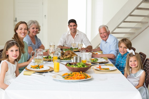 Familia que tiene comida junto a la mesa de comedor