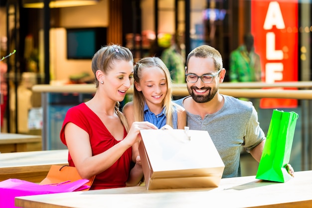 Familia que tiene descanso de compras en centro comercial