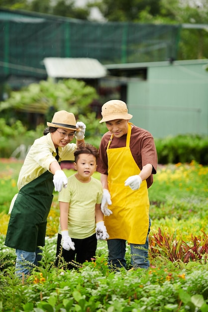 Familia que trabaja en el vivero de flores