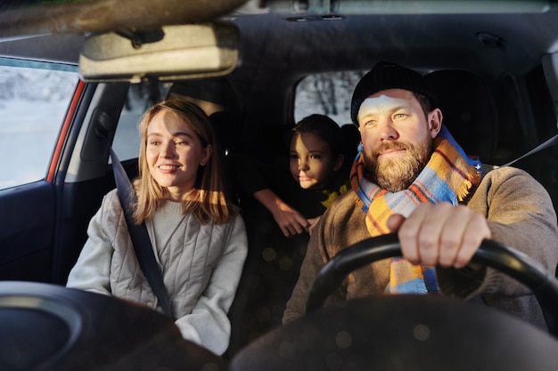 Familia que viaja en coche en invierno