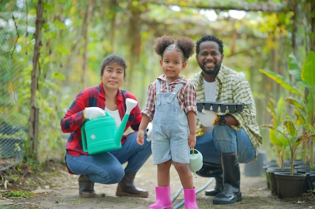 Familia de raza mixta con hija pasando tiempo juntos en la granja orgánica