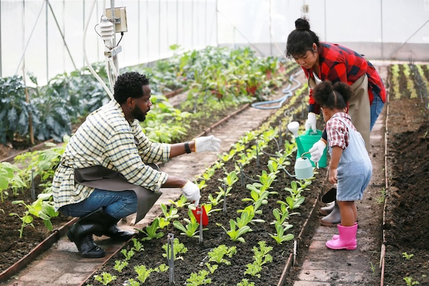 Familia de raza mixta con hija pasando tiempo juntos en la granja orgánica
