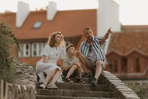 Una familia se relaja en las escaleras entre tejados en un antiguo pueblo europeo