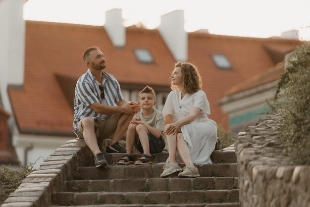 Una familia se relaja en las escaleras entre tejados en un antiguo pueblo europeo