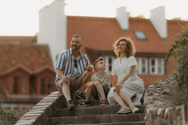 Una familia se relaja en las escaleras entre tejados en un antiguo pueblo europeo