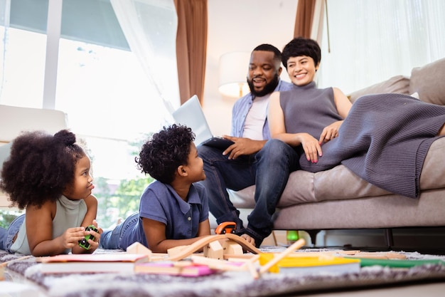 Familia relajándose y jugando en la sala de estar en el piso en fin de semana