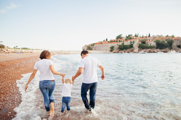 Família relaxa na praia Viagem em família à beira-mar