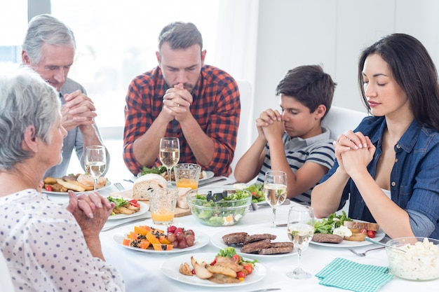 Família rezando juntos antes da refeição