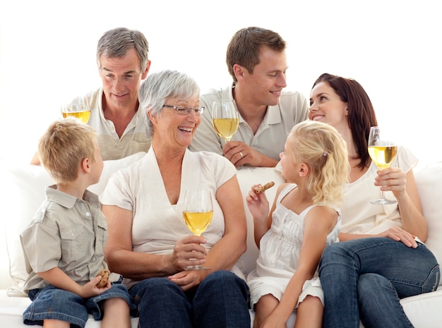 Familia en la sala de estar bebiendo vino y comiendo galletas