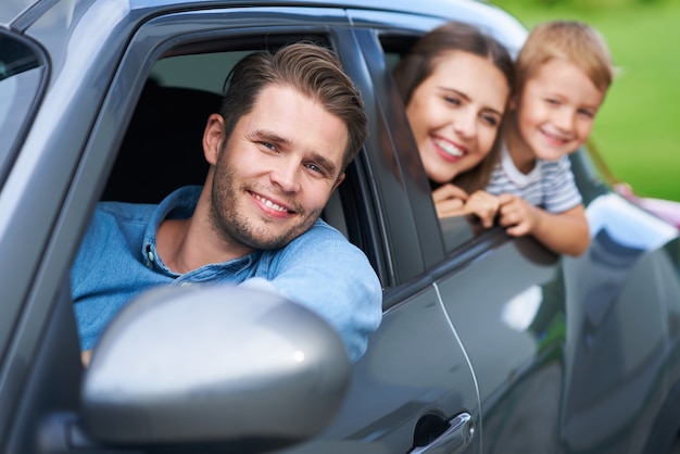 familia sentada en el coche mirando por las ventanas