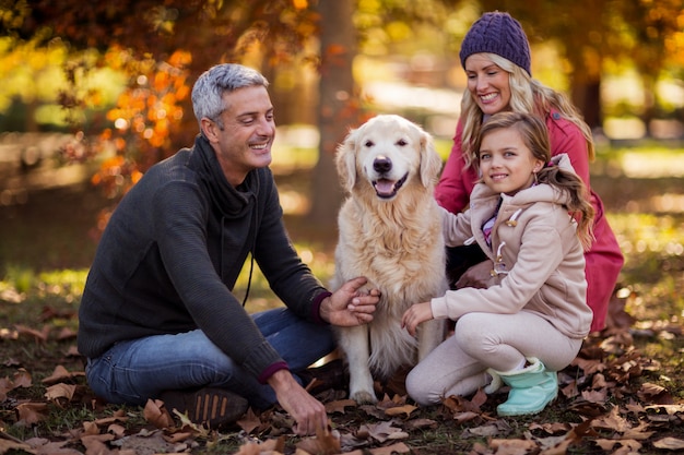 Família sentada com cachorro no parque