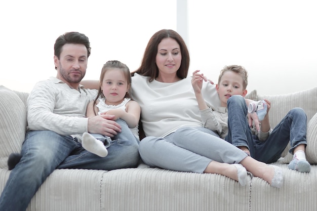 Família sentada no sofá à noite foto gratuita com espaço de cópia