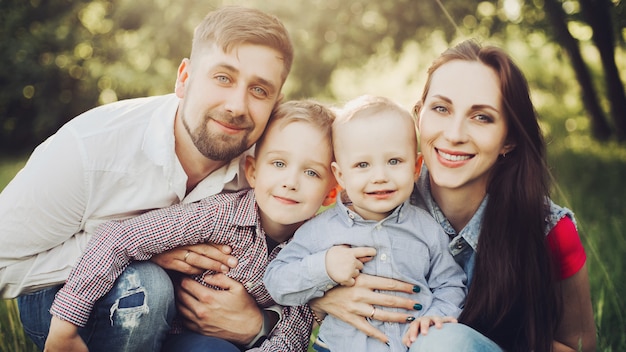 Familia sentada en el parque de rodillas