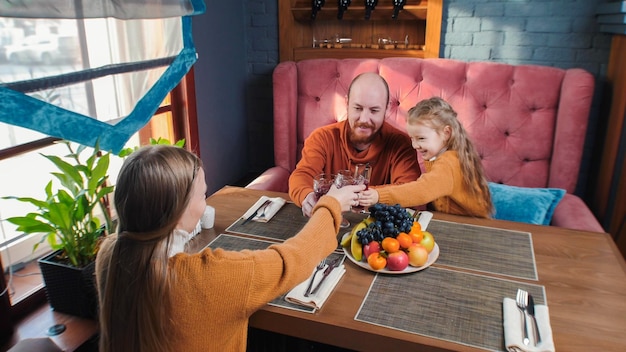 Una familia sentada en el restaurante del hotel tintineando vasos