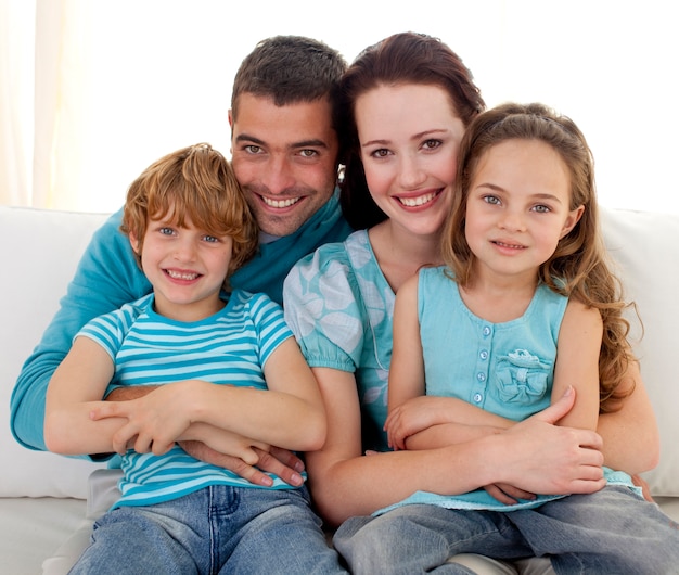 Familia sentada en el sofá junto