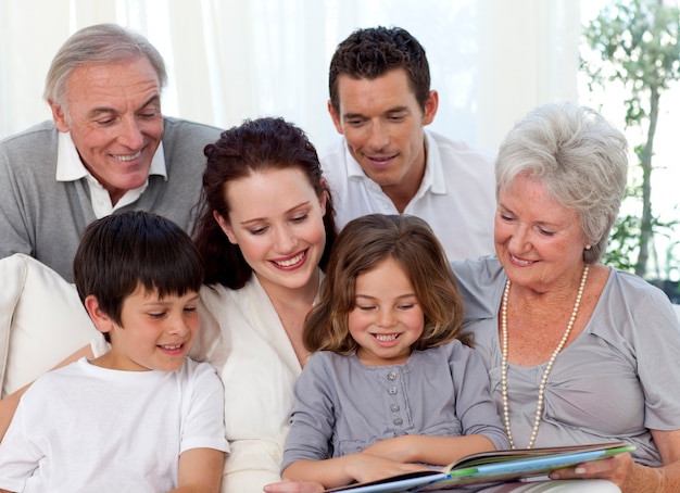 Familia sentada en el sofá leyendo un libro