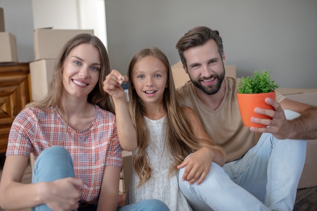 Familia sentada en el suelo y sonriendo