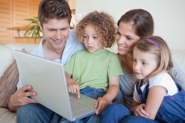 Familia serena usando una computadora portátil