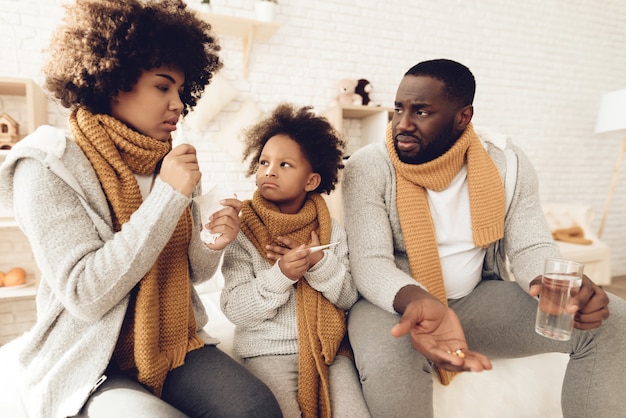 La familia se sienta en casa y tiene un resfriado.