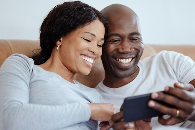 Família significa que ninguém é deixado para trás ou esquecido. Foto de um jovem casal usando um smartphone na cama em casa.