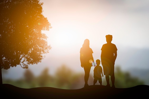 Foto una familia de silueta con un fondo de puesta de sol naranja borroso