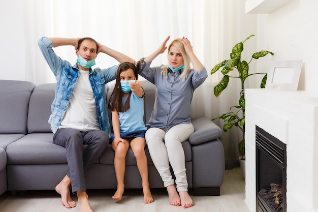 familia en el sofá viendo la televisión en casa. Quédese en casa durante la cuarentena