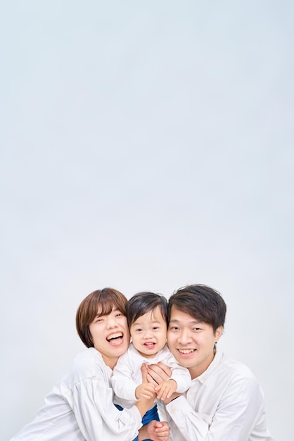 Familia sonriendo y alineándose frente a un fondo blanco