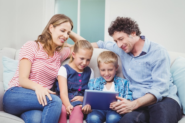 Familia sonriendo y mirando en tableta digital