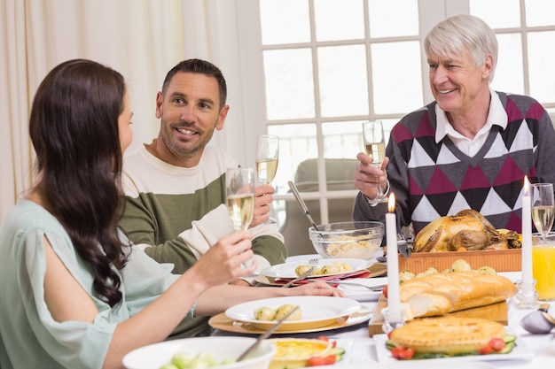 Familia sonriente brindando durante la cena de Navidad