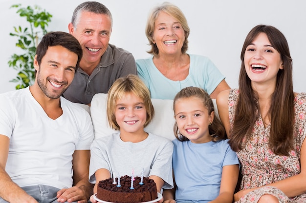 Familia sonriente celebrando con torta de cumpleaños