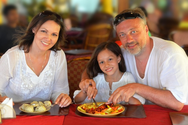 Familia sonriente comiendo en el café